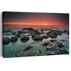 Tranquil rocky shoreline at sunset captured in a stunning coastal canvas print.