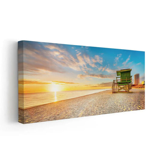 Beach sunrise wall art featuring a lifeguard tower on the shore at dawn.