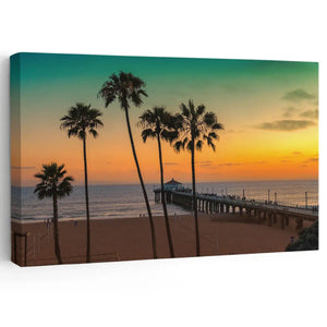 Sunset beach wall art featuring a scenic pier and silhouetted palm trees against a golden sky.