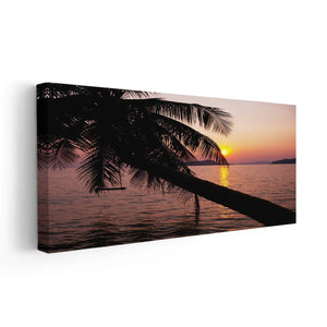 Coastal artwork for bedroom displaying a tranquil tropical ocean sunset with a leaning palm tree on the shore.