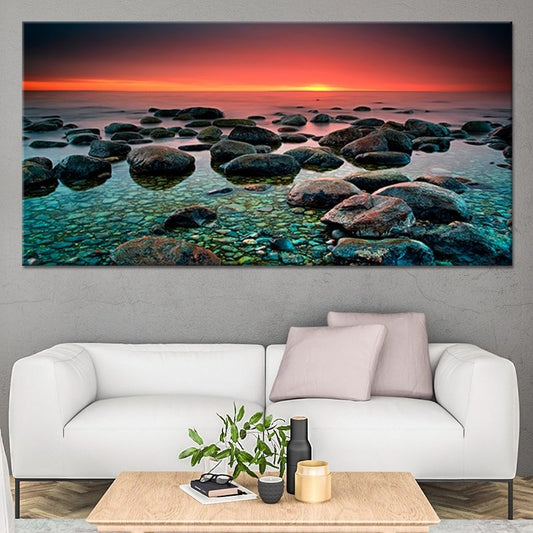 Serene beach rocks at dusk with golden-red sky in a large wall art decor piece.